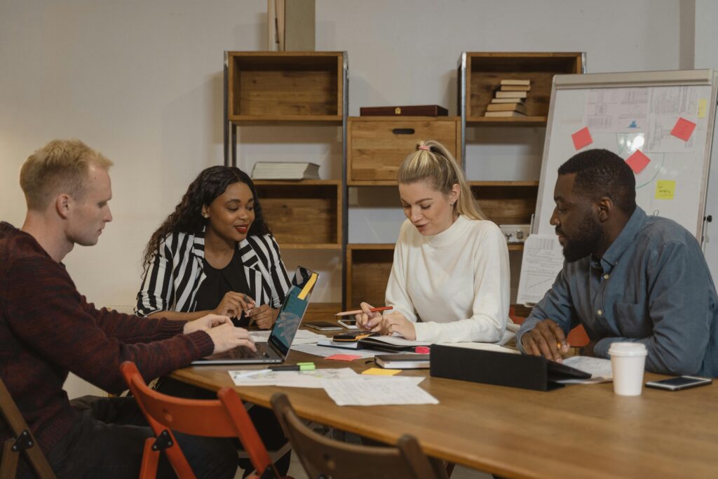 a business operations team huddled behind a laptop